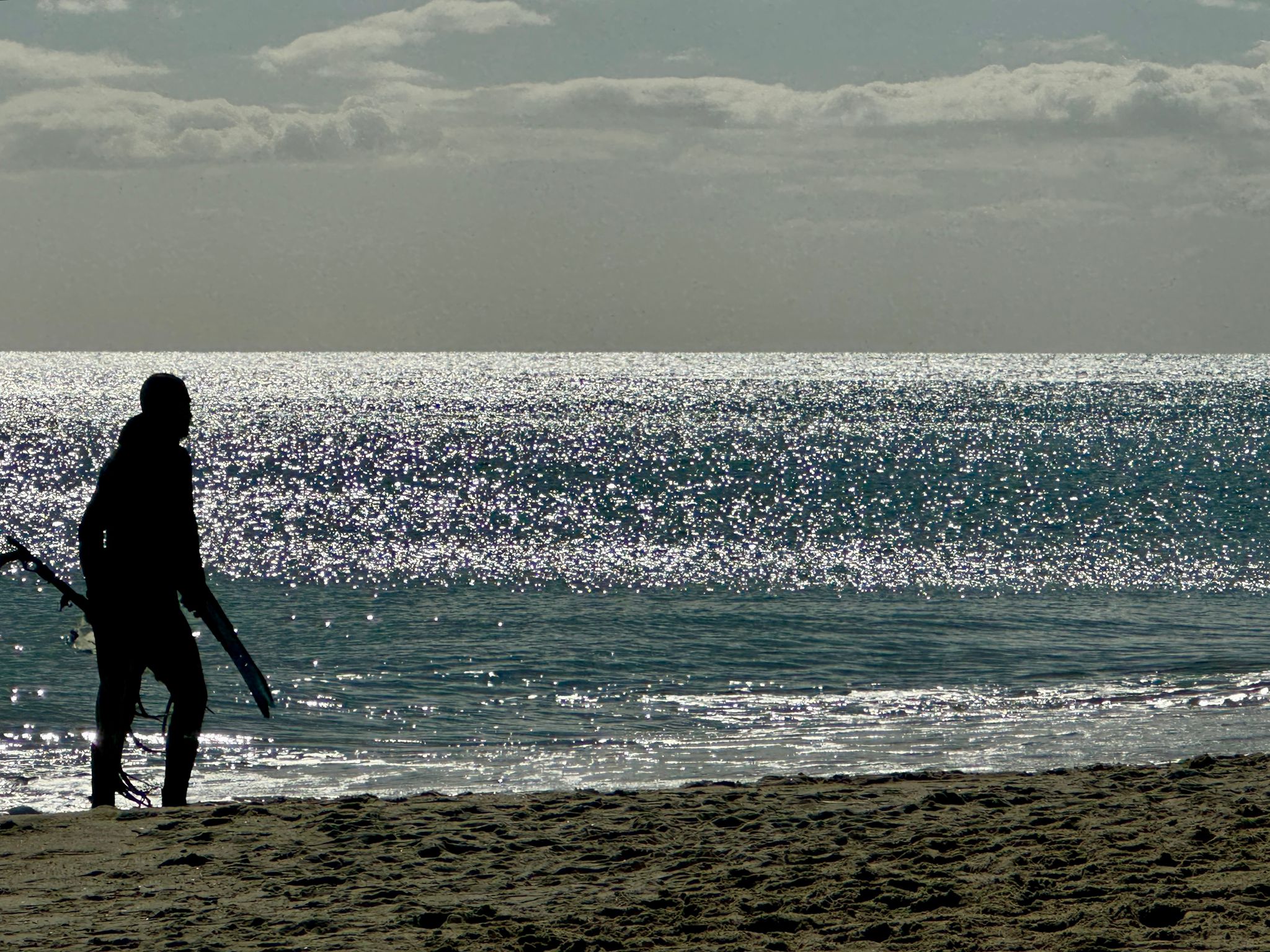 momente-meerschreibzeit2025-mann-mit-harpune-am-strand